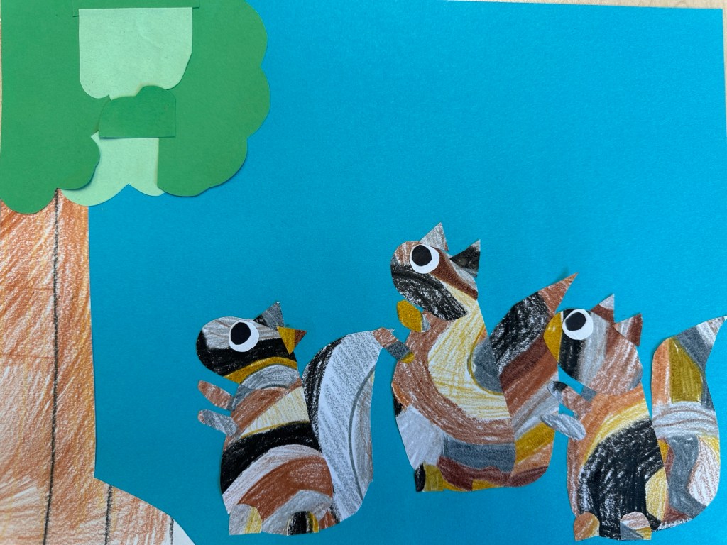 A paper collage of squirrels looking at a tree